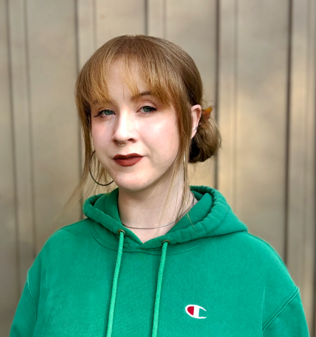 Photo of Rowynne Grant wearing a green sweatshirt and dark lipstick. 