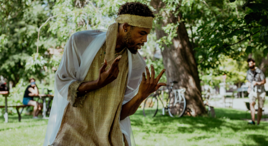 A person wearing a yellow headband and yellow shirt bent over with their hands gesturing expressively. 