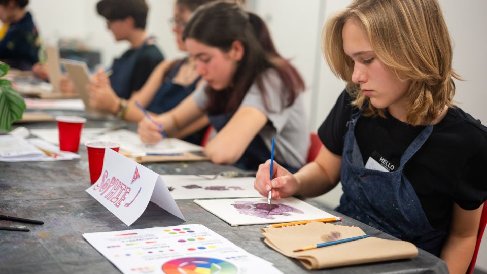 Teenagers sit at a long table oil painting. 